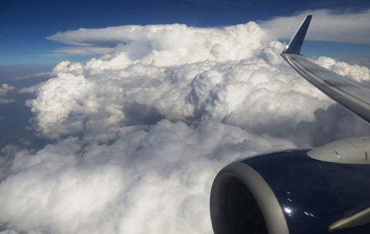 On an airplane above the clouds on the way to your summer destination