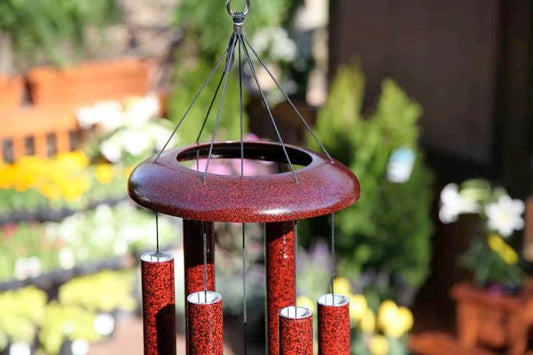 Windchimes hanging with flowers inthe background