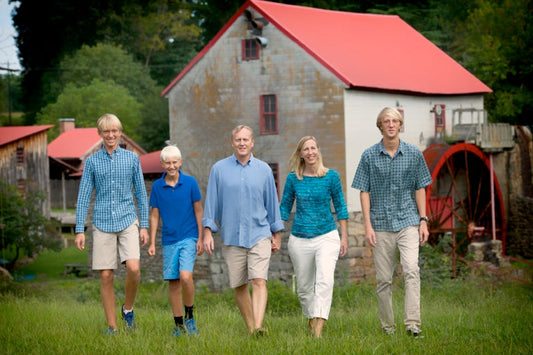 A family walking in front of the Old Mill of Guilford