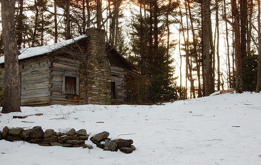 A snow-covered log cabin