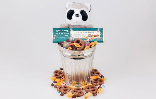 A stuffed racoon holding a Trash Panda Party Chocolate Bar