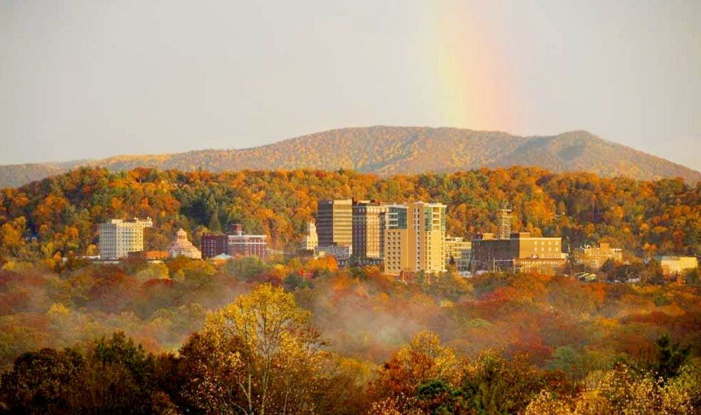 Asheville Skyline from a distance with a rainbow across the sky.