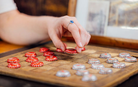 a woman playing a game of bottle-cap checkers