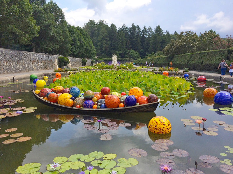 Chihuly exhibit of colorful balls floating in a lilly pad covered pond
