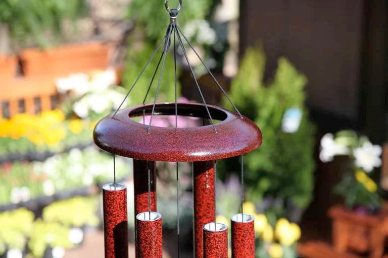 Windchimes hanging with flowers inthe background