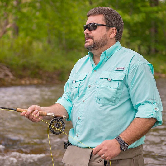 Man fly fishing wearing a blue Columbia  Bahama ll shirt