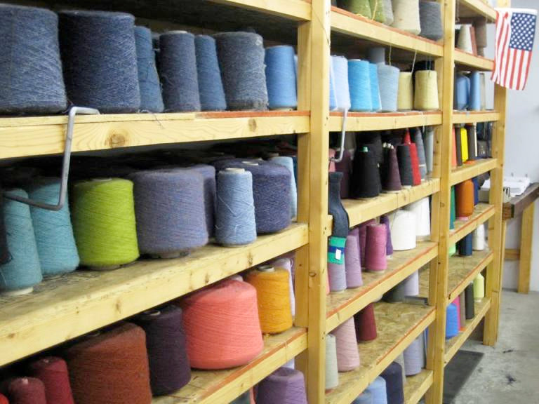 Skeens of colorful yarn on shelves at the Darn Tough Factory