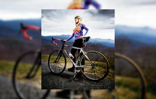 Kimberly Masters standing beside her bike on a mountaintop