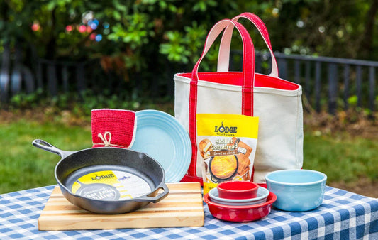 Made in the USA products found at Mast Store on a picnic table including Lodge cast iron, dinnerware, a totebag and a cutting board