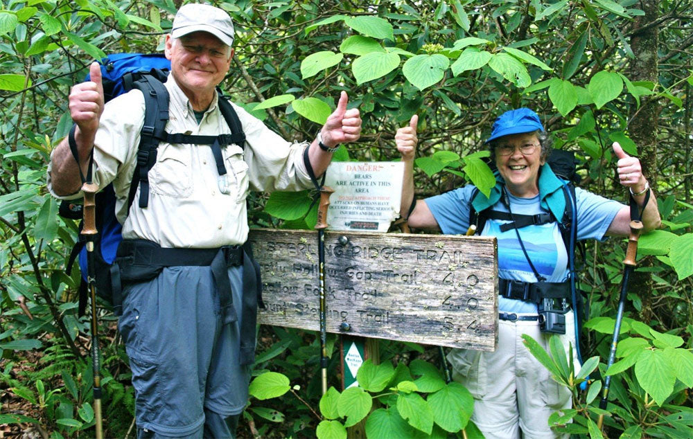 Frank and Peggy in hiking geat standing by trail sign