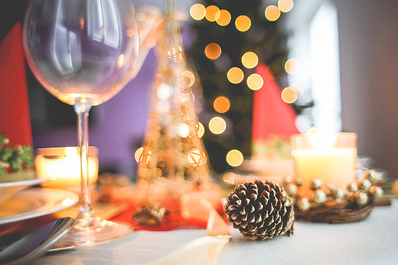 Holiday Table depicting a wine glass and a lit table setting