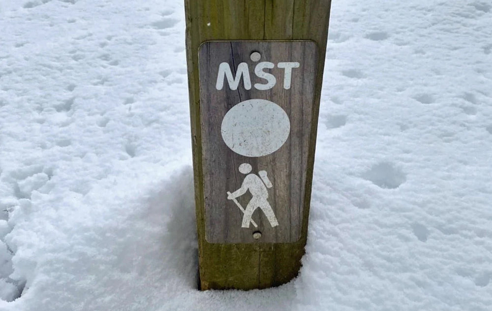 A trail marker for the North Carolina Mountains to Sea Trail in the snow