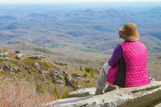 A woman sitting on a rock overlooking the Blue Ridge