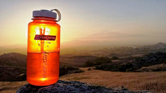 A Nalgene bottle on a rock at sunset