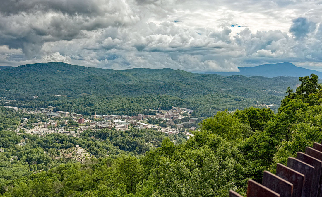 A view of the Town of Boone from Howard Knob Park - long-range view of a town surrounded by mountains, trees, and cloud cover