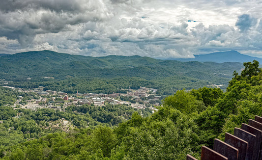 A view of the Town of Boone from Howard Knob Park - long-range view of a town surrounded by mountains, trees, and cloud cover