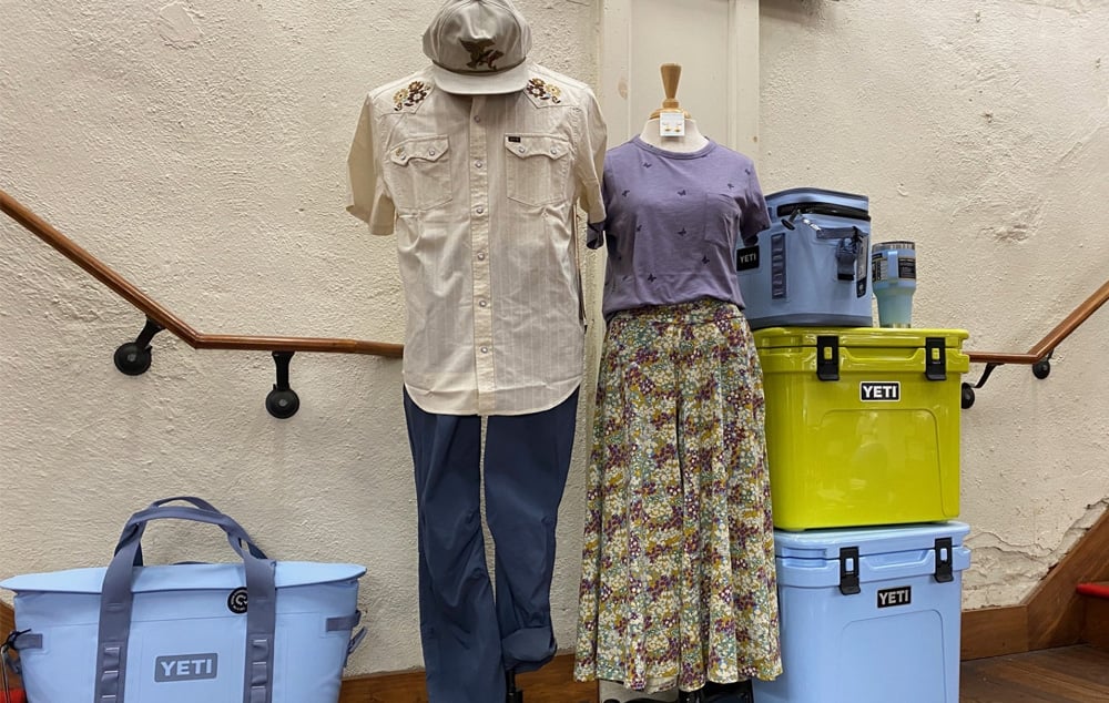 Travel clothes on a mannequin flanked by Yeti coolers in the Mast Store 
