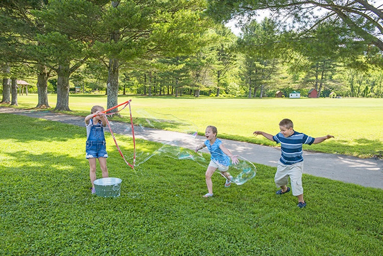Children playing outside with bubbles