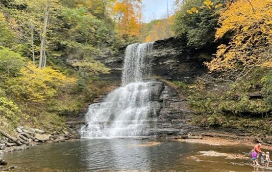 a family standing next to Cascade Falle