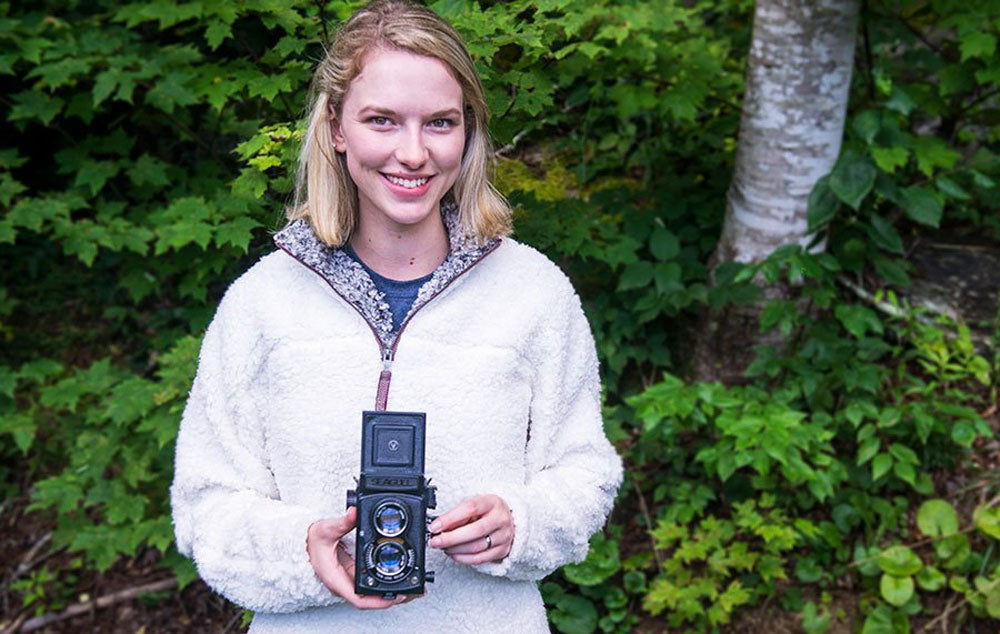 a woman wearing a Frosty Tipped Fleece holding a viewfinder camera