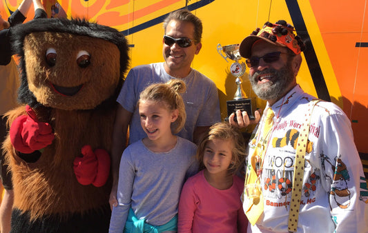 The Woolly Worm mascot alogside participants in the wooly worm race