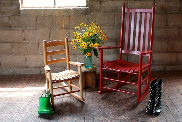A child's rocker and an adult rocker in a rustic room