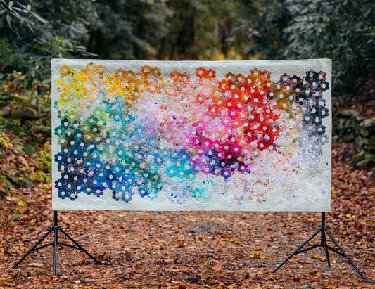 Colorful quilt displayed in a forest setting