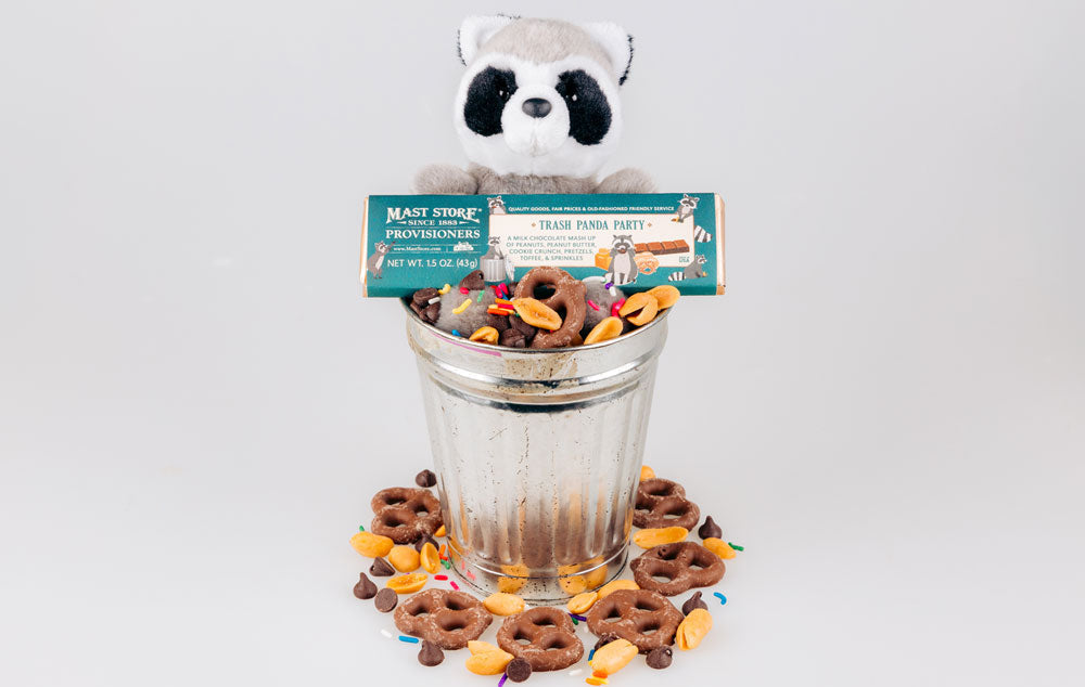 A stuffed racoon holding a Trash Panda Party Chocolate Bar