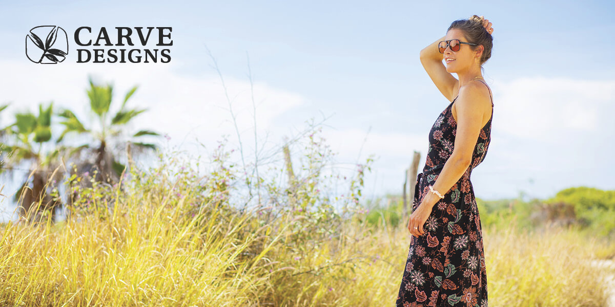 Woman wearing a floral Carve Designs dress standing in a field.
