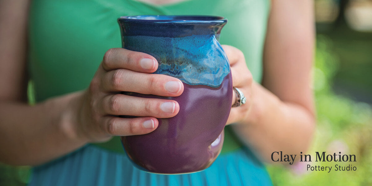 Woman holding a handwarmer mug.