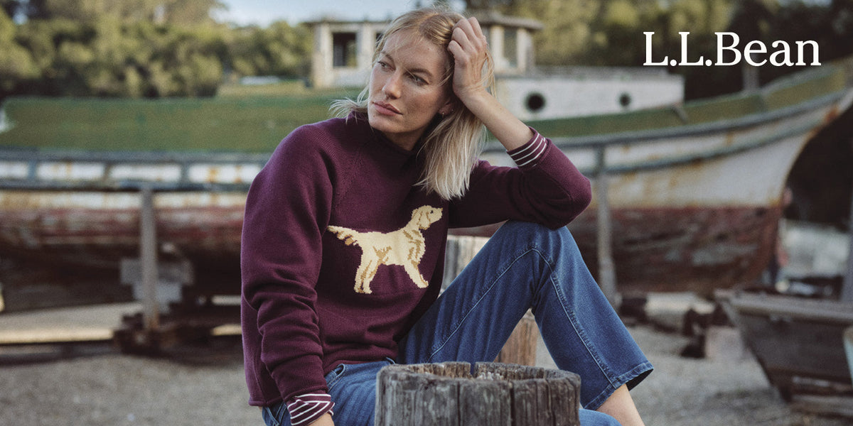 A woman relaxes outdoors in a classic L.L.Bean sweater and blue jeans
