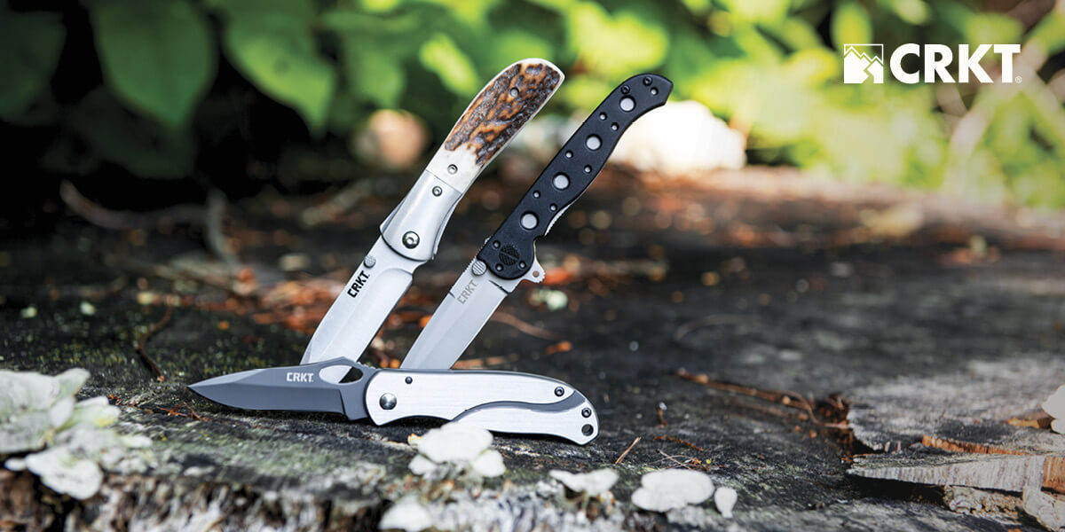 Three CRKT knives on top of a rock.