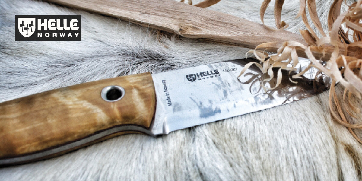Helle knife with a wooden handle resting on a leather hide.