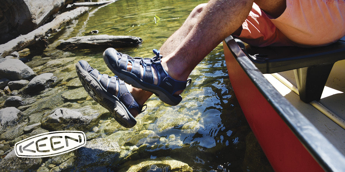 Person wearing KEEN shoes by a river.