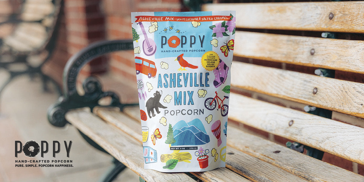 Pack of Poppy Hand‑Crafted Popcorn Asheville Mix resting on a wooden bench.