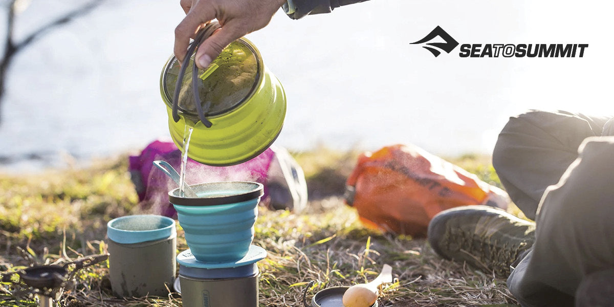 Person brewing a drink outdoors with Sea to Summit gear.