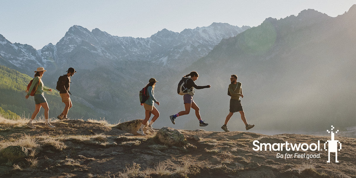 People hiking through a mountainous landscape while wearing Smartwool socks.