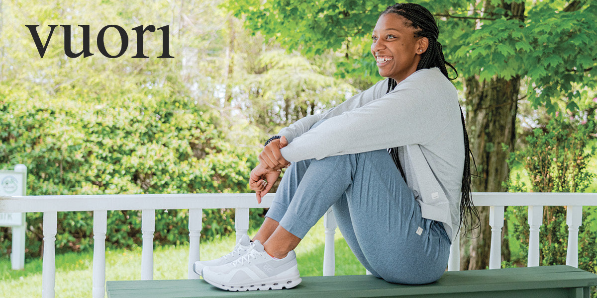 Woman relaxing on a bench outdoors in Vuori clothing.