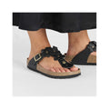 Stylish black flower-adorned flip-flops with a cork sole, perfect for summer comfort and fashion.