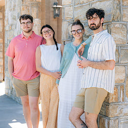 Four friends standing together on a sidewalk in relaxed spring and summer styles from Mast Store