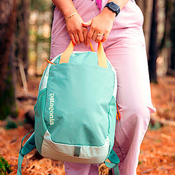 Person holding a Patagonia backpack in a forest setting